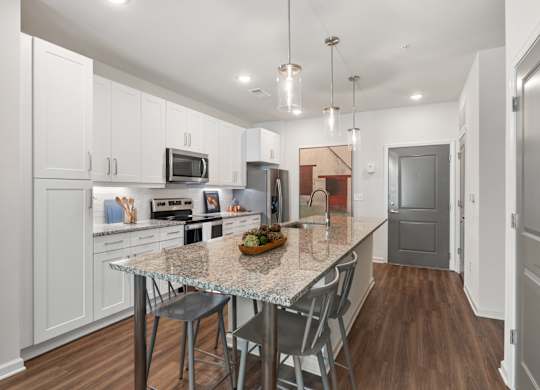 A kitchen with a table and chairs in the middle of it.