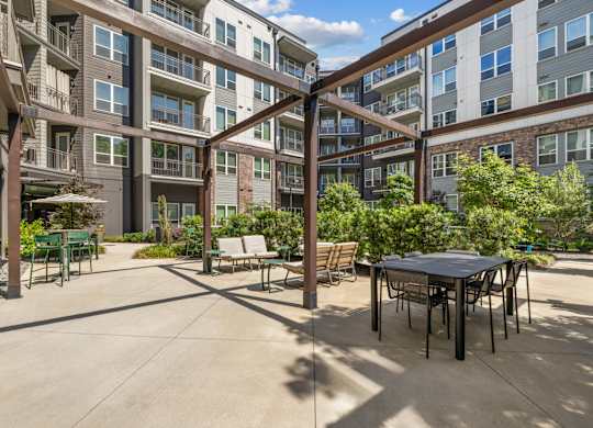 A patio area with a table and chairs surrounded by apartment buildings.