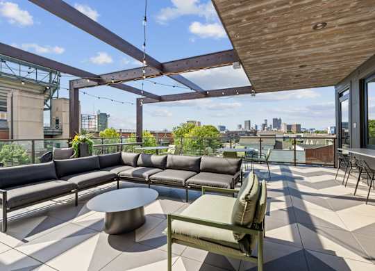 A patio with a table and chairs overlooking a city skyline.
