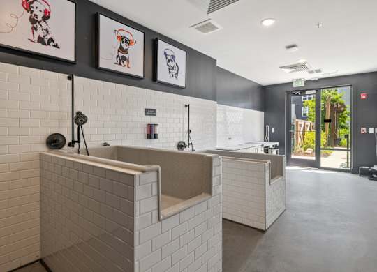 A bathroom with a white tiled wall and a white sink.