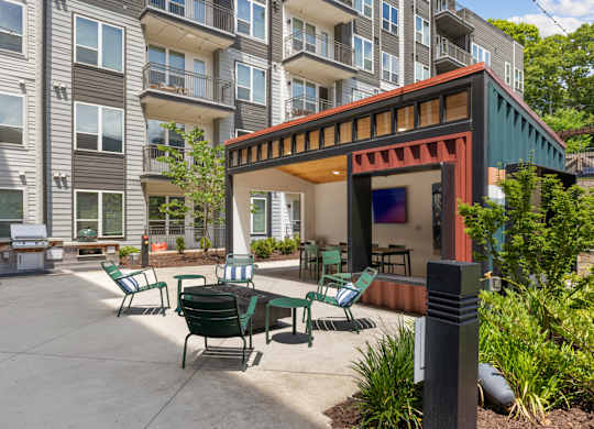 A patio with a table and chairs is surrounded by apartment buildings.
