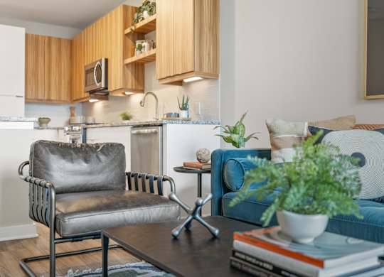 A modern kitchen with a grey chair and a blue couch.