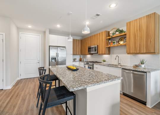 A kitchen with a granite countertop and wooden cabinets.