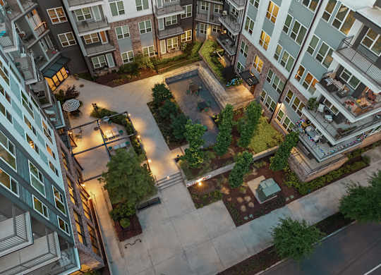 A courtyard surrounded by apartment buildings at night.
