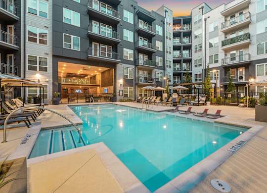 A large swimming pool in front of apartment buildings.