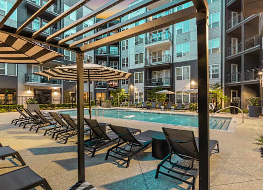 A pool area with sun loungers and a canopy.
