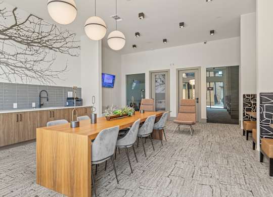 A modern dining room with a long table and chairs.