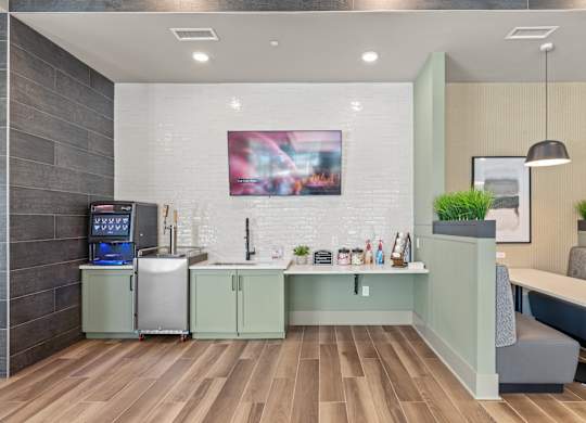 A modern kitchen with a wooden floor and a fridge on the left.