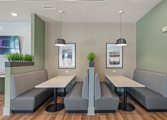 A modern dining area with grey booths and white tables.