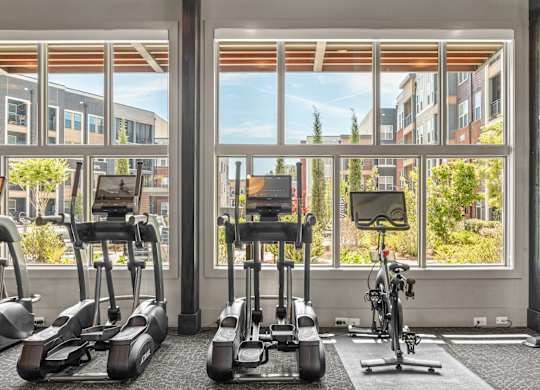 A gym with treadmills, exercise bikes, and a weight machine.