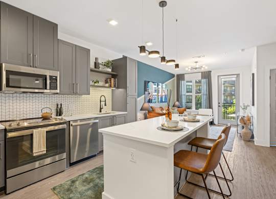 A modern kitchen with a dining table set for two.