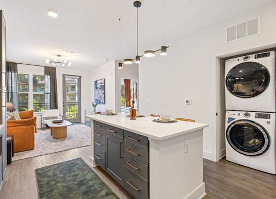 A modern laundry room with a washer and dryer built into the cabinetry.
