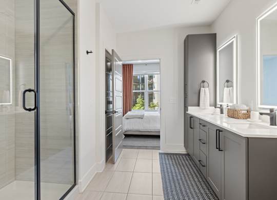 A bathroom with a walk-in shower and a double vanity.