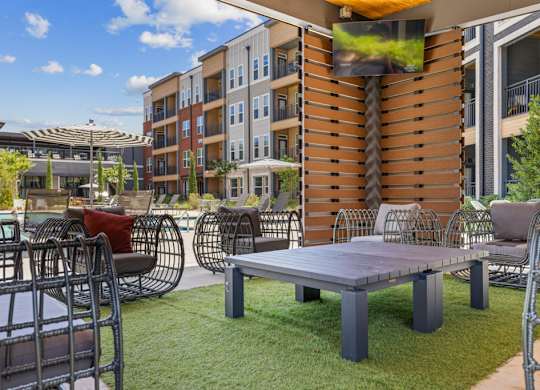 A patio with a table and chairs is in front of a building.
