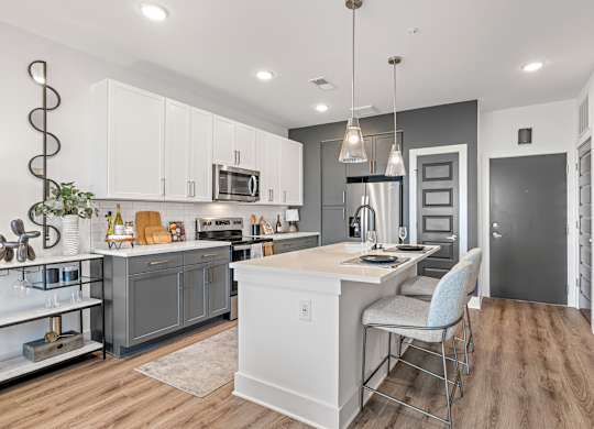 A modern kitchen with a large island and a dining area.