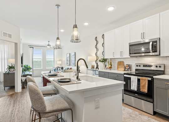 A modern kitchen with a large island and a dining area.