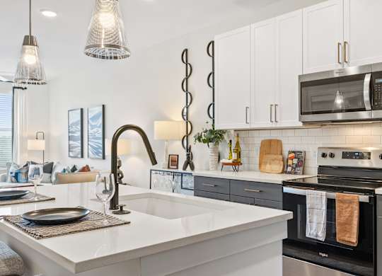 A modern kitchen with a white countertop and a black oven.