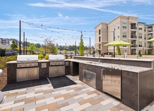 an outdoor kitchen with stainless steel appliances and a marble countertop