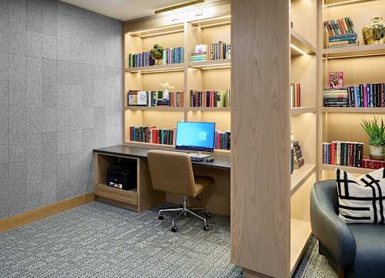 A room with a desk, chair, and bookshelf.