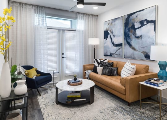A living room with a brown couch, a coffee table, and a painting on the wall.