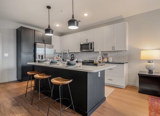 a kitchen with a large island with three stools