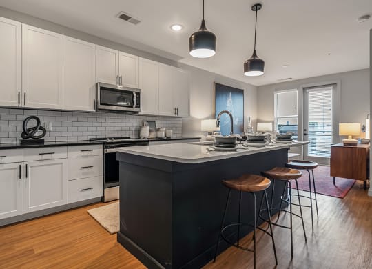 an open kitchen with a large island with three stools
