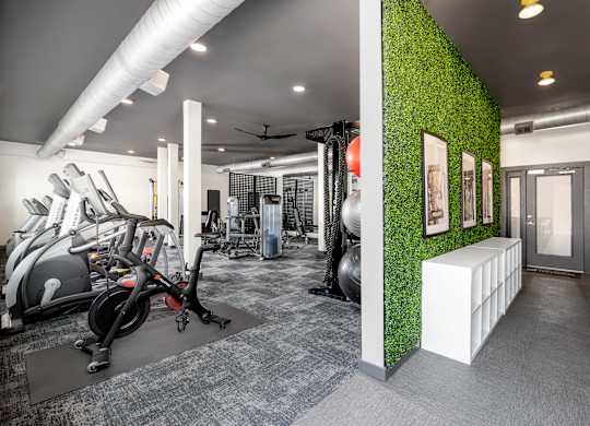 A gym with a green wall and exercise equipment.