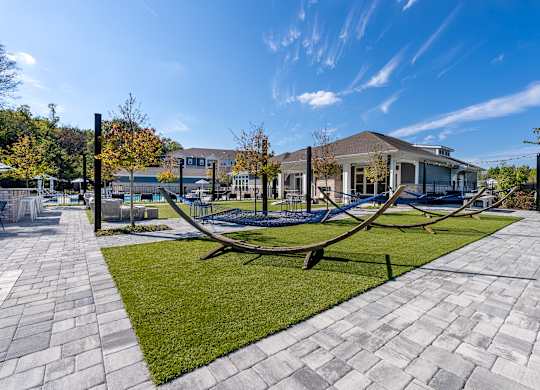 A playground with a swing set in the foreground and a building in the background.
