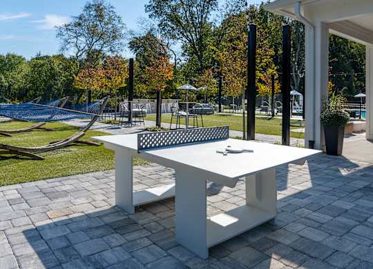 A white table with a black screen on top is in the middle of a paved area.
