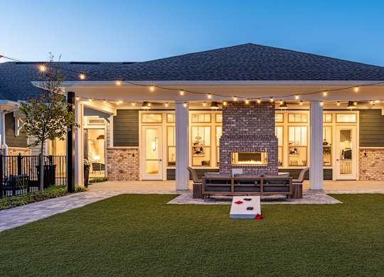 A house with a covered patio and a fireplace.