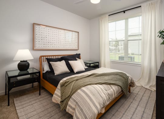 a bedroom with a bed and a window with white curtains