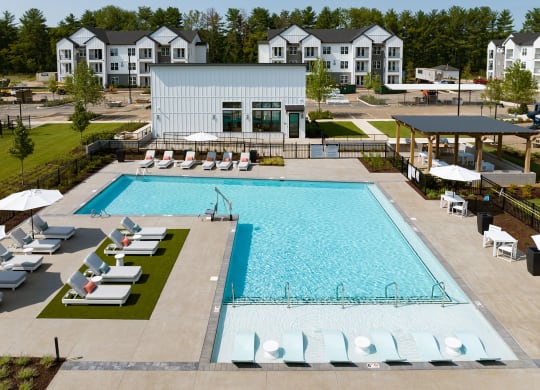 an aerial view of a swimming pool with lounge chairs around it