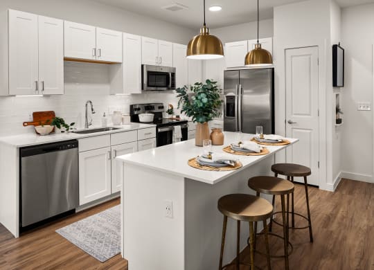 an open kitchen with a center island and stainless steel appliances