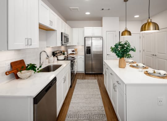 a large white kitchen with white cabinets and stainless steel appliances