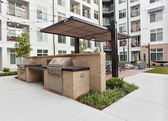 a bbq area with an apartment building in the background
