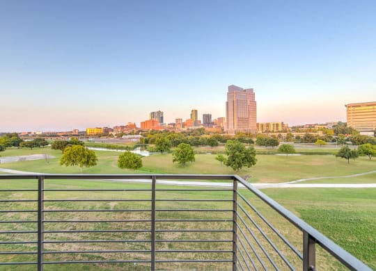 a view of the city skyline from a balcony overlooking a park