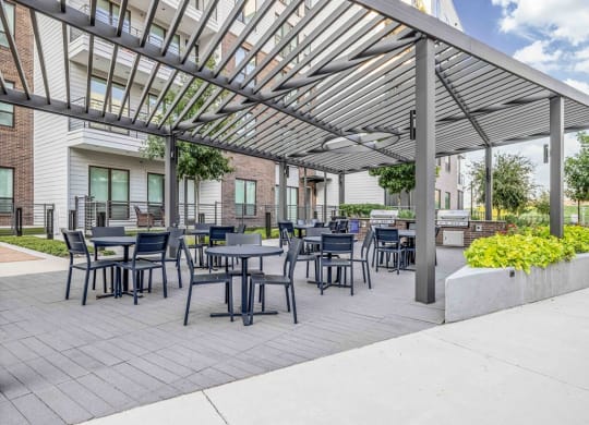 a patio with tables and chairs under awning