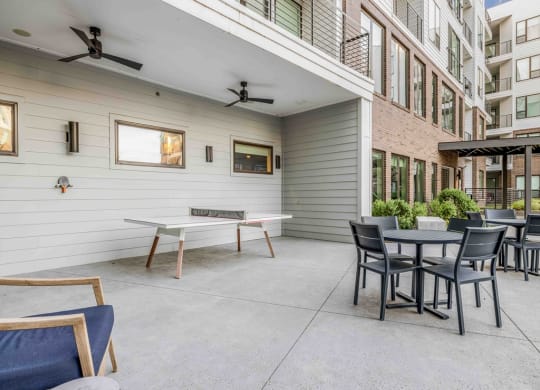 the outdoor patio has tables and chairs and a fire pit