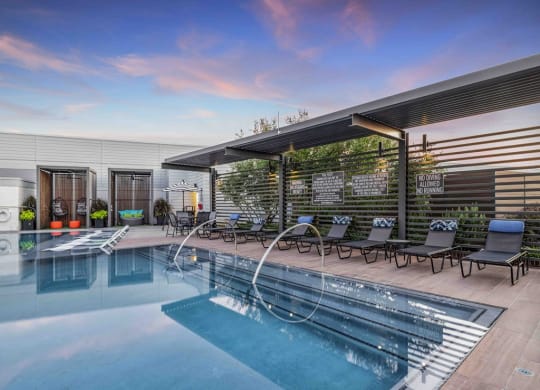 a swimming pool with lounge chairs and a roofed pool