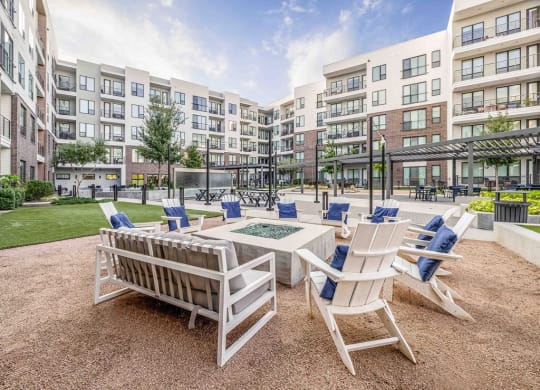 an outdoor patio with chairs and tables and an apartment building