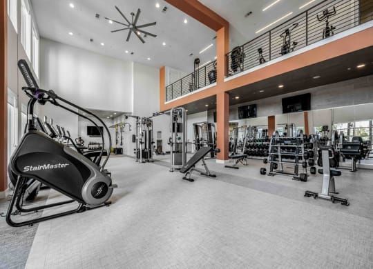 a gym with weights and cardio equipment in the lobby of a building