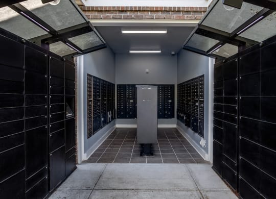 a look down a hallway with black tiles and a gray column in the middle