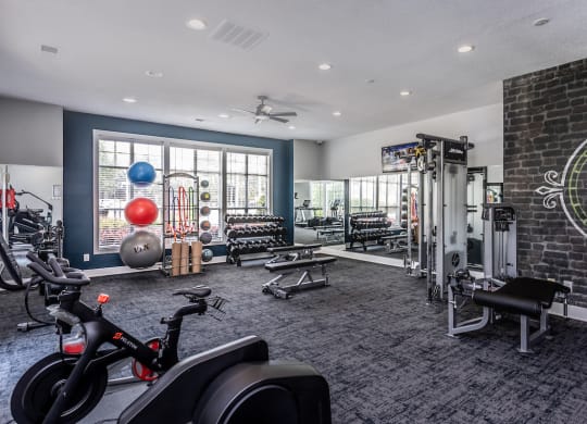 a gym with a brick wall and lots of exercise equipment