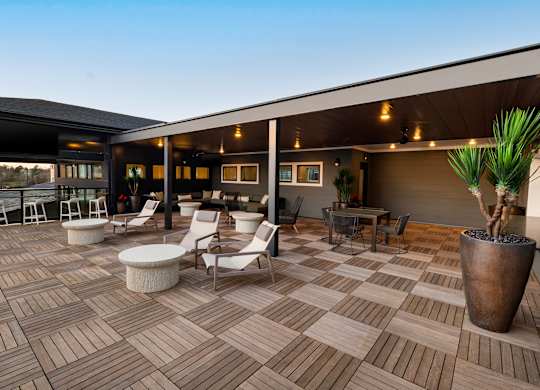 a patio with chairs and tables and a building in the background