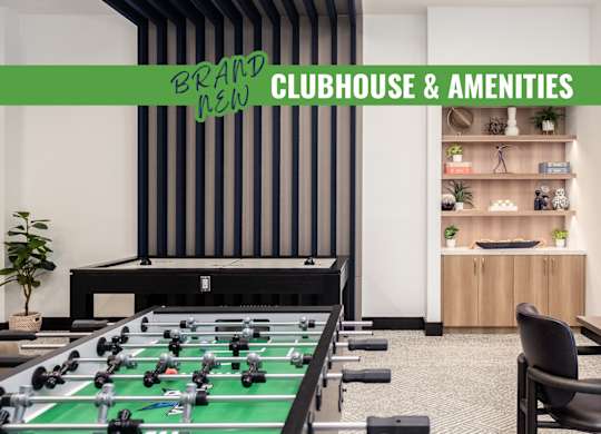 A foosball table is in the middle of a room with a green table top.