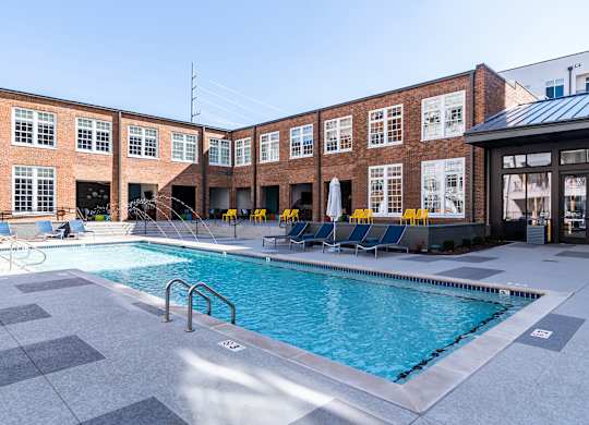 a swimming pool in front of a brick building