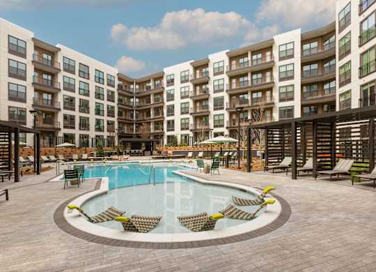 a large swimming pool in front of an apartment building