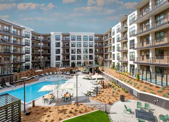 A large apartment complex with a pool and a patio area.