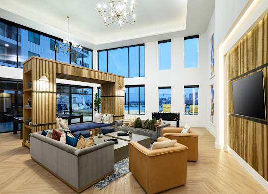 A modern living room with a large sectional sofa and a chandelier.
