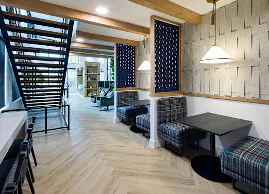 A room with a wooden floor and a wall with a patterned tile design.